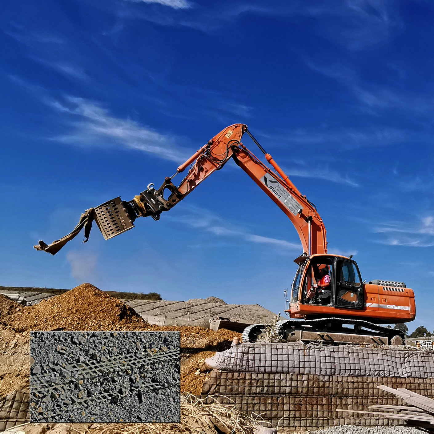 Ein Bagger mit ausgefahrenen Arm steht auf einem Kieshaufen